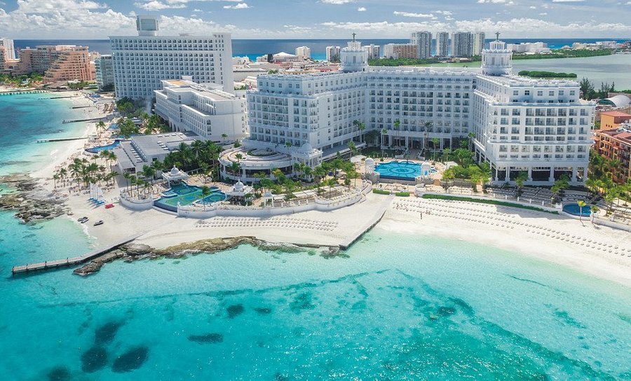 Riu Palace Las Americas adults-only all-inclusive resort in Cancun Hotel Zone with oceanfront pools, elegant architecture, and white sand beach.