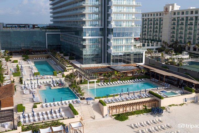 Secrets The Vine Cancun adults-only luxury all-inclusive resort with sleek modern tower, beachfront setting, and romantic atmosphere.