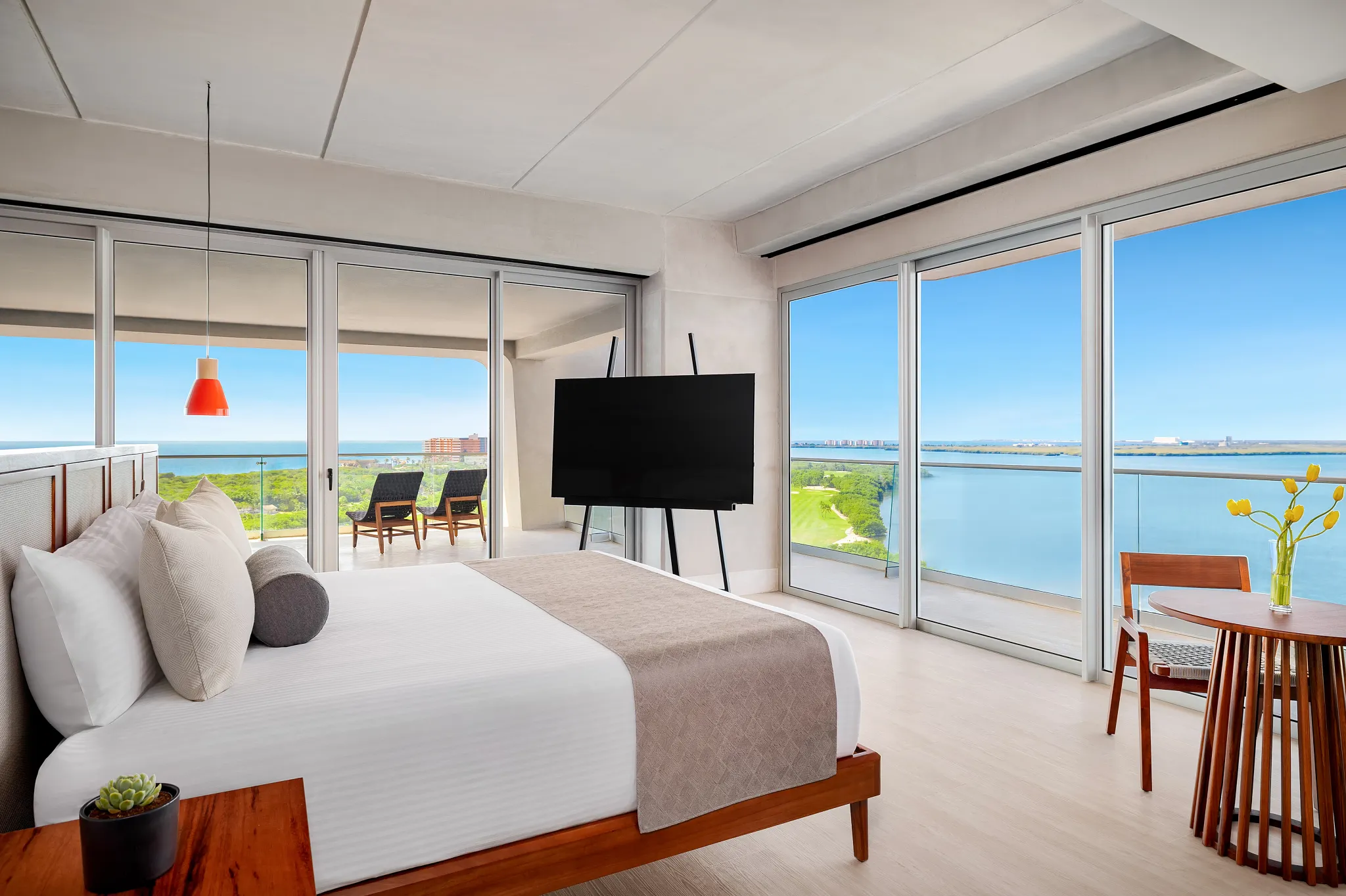 Vivid Suite bedroom with king bed, floor-to-ceiling windows, and bay view balcony at Hyatt Vivid Grand Island.